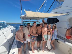 A lively group of friends enjoys a sunny day on the boat, capturing memories and celebrating together — perfect for summer outings and gatherings on the water.