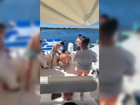 A lively group enjoys drinks and fun on a boat, showcasing the perfect atmosphere for a day out on the water.