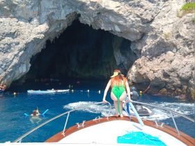 A vibrant scene of adventure as guests enjoy snorkeling near a stunning cave entrance, showcasing the thrill of exploring underwater wonders.