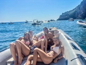 A group of friends relaxes on a boat under the sun, enjoying a fun day on the water — perfect for summer outings and beach adventures.