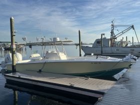 A pristine center console boat docked at the marina, showcasing its sleek design against a tranquil water backdrop — perfect for fishing or day trips.
