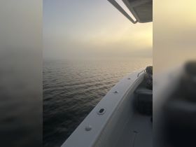 A foggy scene on the water with a partial view of a boat's interior, creating an ambiguous atmosphere.