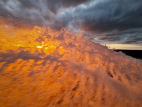 A stunning sunset reflects off the ocean waves, creating a vibrant display of colors — a perfect moment capturing the beauty of nature at sea.