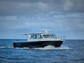 A sleek speedboat named Triton cruises through open waters, showcasing its impressive design and performance.