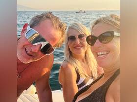 A cheerful group enjoys a sunset moment on the water, capturing smiles and good vibes — perfect for memorable boating experiences.