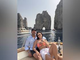A couple enjoys a picturesque moment aboard a boat, with stunning rock formations in the background — perfect for romantic getaways and scenic tours.