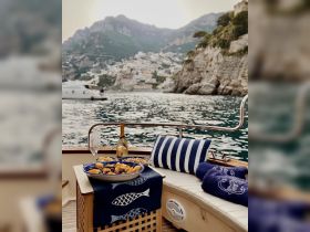 A beautifully arranged spread of snacks and champagne on a boat, perfect for enjoying the stunning coastal views of Amalfi. Ideal for a relaxing day on the water.