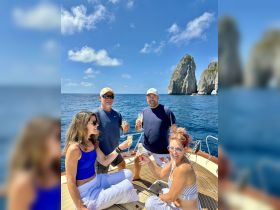 A joyful group celebrates with cocktails aboard a yacht, surrounded by stunning coastal scenery — perfect for memorable gatherings on the water.