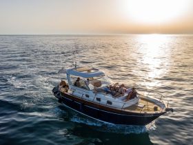A group enjoys a relaxing sunset cruise aboard a stylish yacht, capturing the essence of leisure and camaraderie on the water.