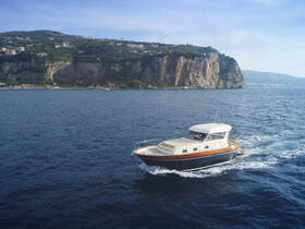 A stunning aerial view of a yacht cruising through clear waters, with a picturesque cliffside backdrop, perfect for showcasing luxury boating experiences.
