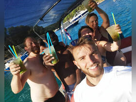 A joyful group raises their cocktails in celebration aboard a boat, capturing the essence of a fun-filled day on the water.
