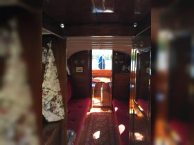 Interior view of a cozy boat cabin featuring plush seating and wooden finishes, perfect for relaxing during a day on the water.