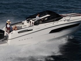 A couple enjoys a thrilling ride on a Karnic CS700 speedboat, showcasing the excitement of cruising through open waters.