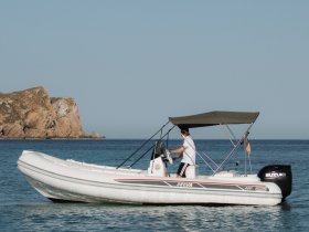 A Selva boat is underway with a captain at the helm, navigating through calm waters — perfect for exploring coastal destinations.