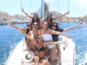 A lively group of friends celebrates on the deck of a yacht, enjoying the sun and ocean views — perfect for a fun day out on the water.