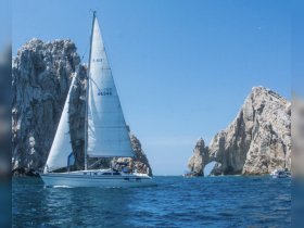 A beautiful sailboat navigates the stunning coastline near iconic rock formations, showcasing the perfect blend of adventure and breathtaking scenery on the water.