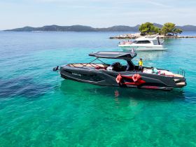 A family enjoys a sunny day on a sleek boat in crystal-clear turquoise waters, perfect for summer adventures and relaxation.