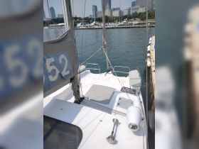 A view of the interior seating area on a sailboat, showcasing the helm and spacious layout, perfect for relaxing while cruising.
