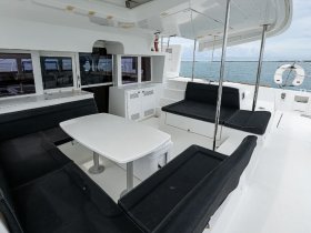 A spacious and modern interior of a boat featuring comfortable seating and a dining area, perfect for relaxing while enjoying the views on the water.