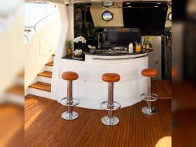 A stylish interior view of a yacht's bar area featuring sleek seating and elegant decor, perfect for entertaining guests on board.