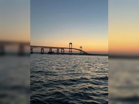 A stunning sunset view of a bridge silhouetted against the colorful sky, capturing the serene beauty of the waterway.