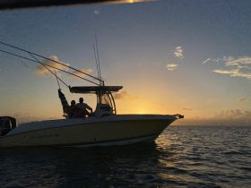 A couple enjoys a serene sunset on a fishing boat, creating a romantic atmosphere perfect for evening cruises.