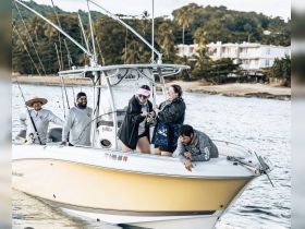 A lively group enjoys a fishing trip on a boat, showcasing camaraderie and excitement on the water.