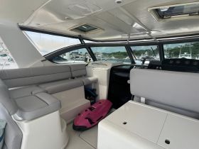 Interior view of a modern boat cabin featuring comfortable seating and a well-equipped helm, perfect for a day on the water.