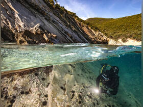 A diver explores the underwater landscape, showcasing the beauty of marine life and rocky formations — perfect for adventure seekers and underwater enthusiasts.
