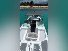 An interior view of a boat showcasing the helm and seating area, with a guest relaxing on board. Perfect for exploring the beautiful turquoise waters.
