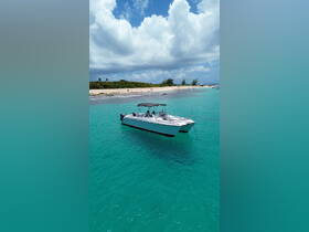 A sleek speedboat anchored in crystal-clear turquoise waters, surrounded by a picturesque beach — perfect for a day of relaxation and adventure on the water.