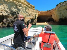 Guests enjoy a guided boat tour exploring stunning coastal caves, with a knowledgeable guide sharing insights about the breathtaking scenery.
