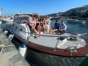 A lively group of friends enjoys a sunny day aboard a boat, perfect for celebrations and memorable outings on the water.