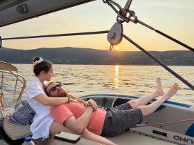 A couple enjoys a romantic moment on a boat at sunset, creating a perfect backdrop for love and relaxation on the water.