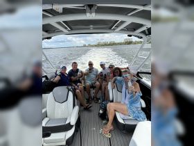 A lively group enjoys drinks aboard a boat, celebrating together on the water — perfect for memorable outings and gatherings.