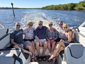 A cheerful group of friends enjoys a day on the water, capturing the essence of fun and relaxation aboard their boat.