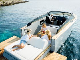 A lively group enjoys drinks and relaxation on a stylish boat, perfect for summer outings and celebrations on the water.
