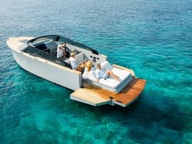 A group enjoys a luxurious day on the water, sipping cocktails and sunbathing on a stylish boat, surrounded by crystal-clear waters — the perfect setting for a summer getaway.