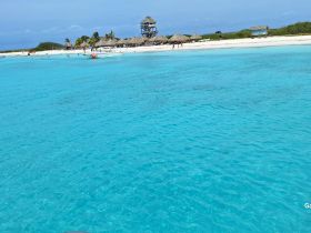 A stunning view of a tropical beach with turquoise waters and visitors enjoying the sun — a perfect destination for relaxation and adventure.