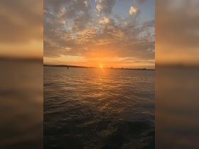 A stunning sunset over the water, casting golden hues across the waves — perfect for capturing the serene beauty of evening boat rides.