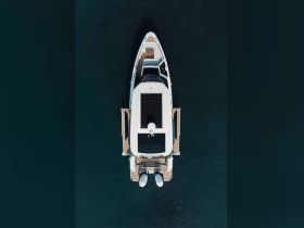 Aerial view of a sleek yacht showcasing its elegant design and spacious deck, perfect for luxury cruising on the open water.