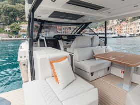 A stylish interior view of a modern boat featuring comfortable seating and a well-equipped helm, perfect for relaxing and navigating on the water.
