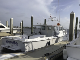A clear view of the 'Piper's Lady' boat docked at the marina, showcasing its structure and design against a serene water backdrop.