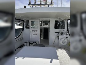 Interior view of a boat's helm and cabin area, showcasing the clean and functional design, ideal for fishing trips or leisure cruising.
