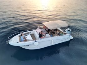 A couple enjoys drinks on a boat during sunset, creating a perfect atmosphere for relaxation and romance on the water.