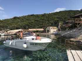 A lively group enjoys a day on the water aboard a boat, surrounded by stunning coastal scenery — perfect for summer adventures and relaxation.