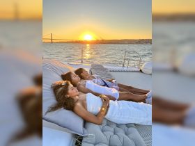 Three friends relax on a yacht as the sun sets, creating a perfect backdrop for a memorable evening on the water.