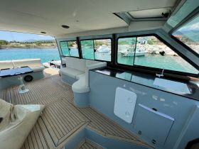 A spacious interior view of a boat's cabin featuring comfortable seating and a well-equipped helm, perfect for relaxing and navigating on the water.