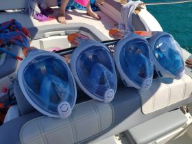 A collection of snorkel masks laid out on a boat, ready for an underwater adventure. Perfect for exploring vibrant marine life while enjoying a day on the water.