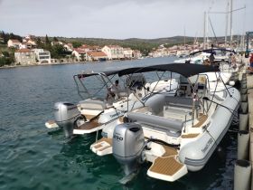 A sleek speedboat docked at a marina, showcasing its modern design and powerful engines, perfect for thrilling water adventures.